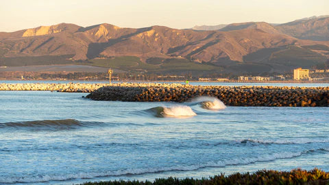 View of ventura harbor beach with waves breaking. Ventura Westside hills in the background early morning light